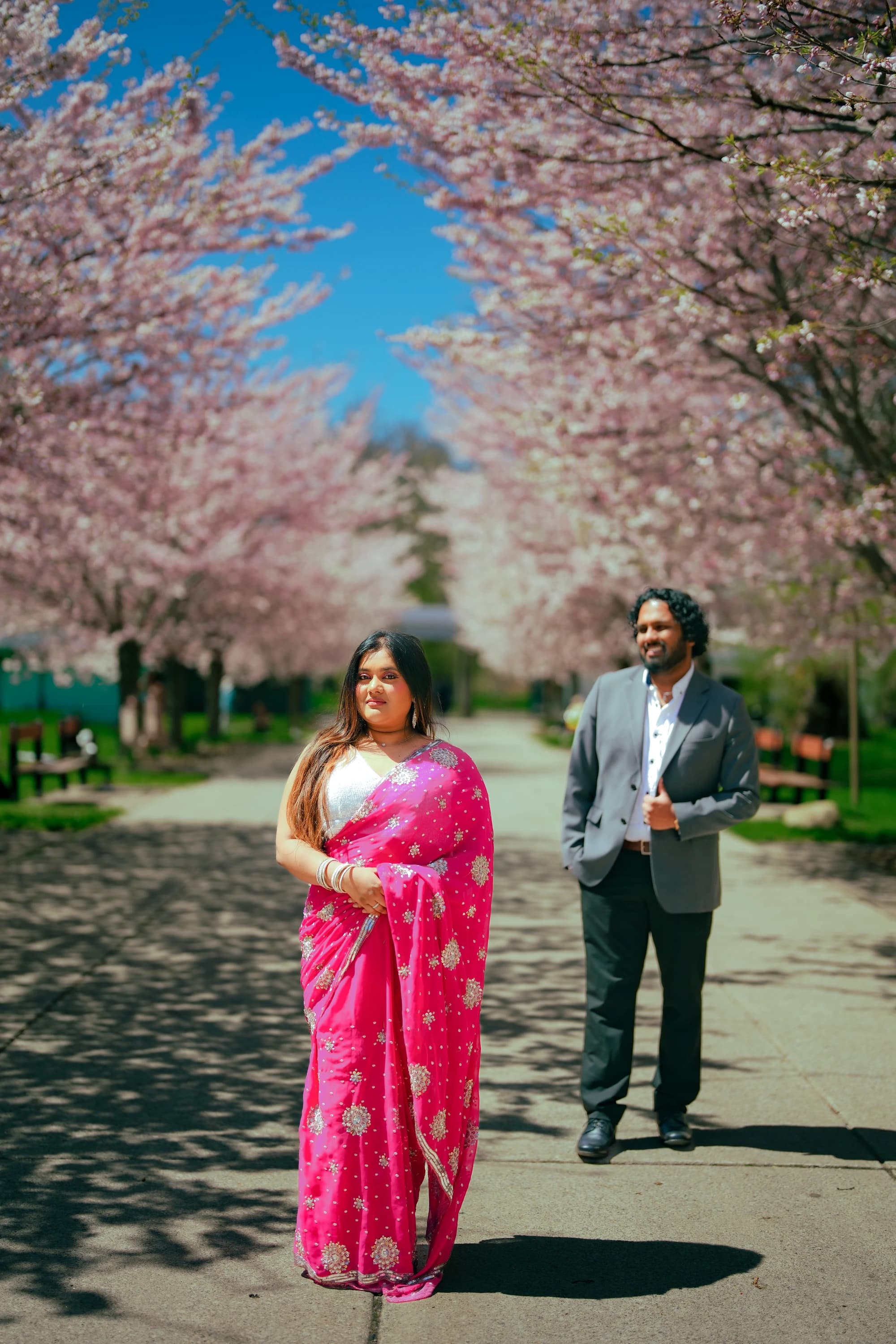 Arnab and Sudipra standing together under blossoms